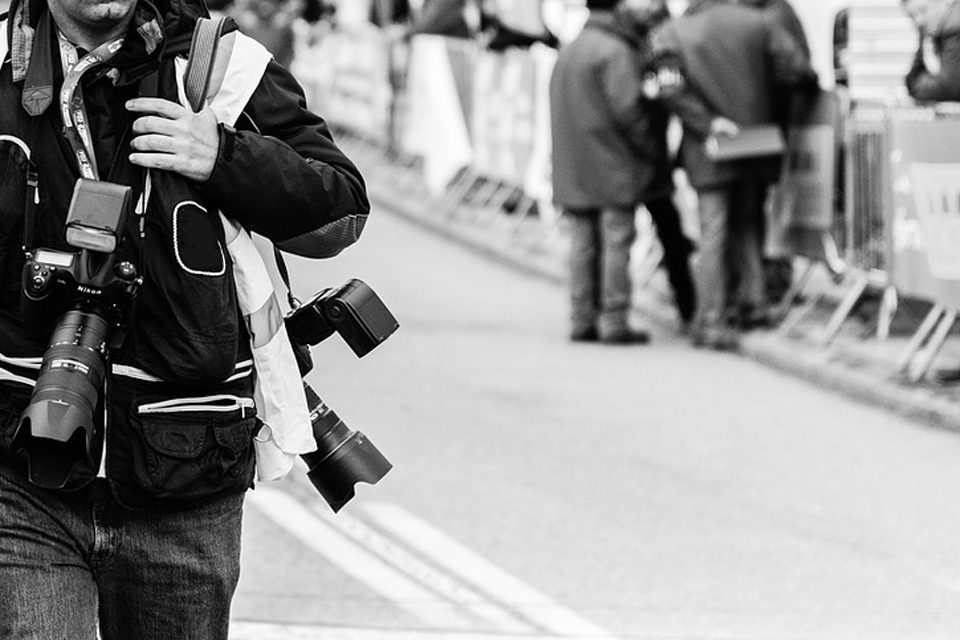 A photographer walking down the street.