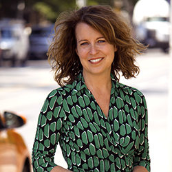 Head shot of Lisa Taylor in a green patterned dress.